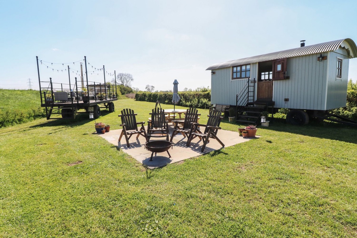 Sweet Caroline Shepherds Hut with deck seating and open countryside around it