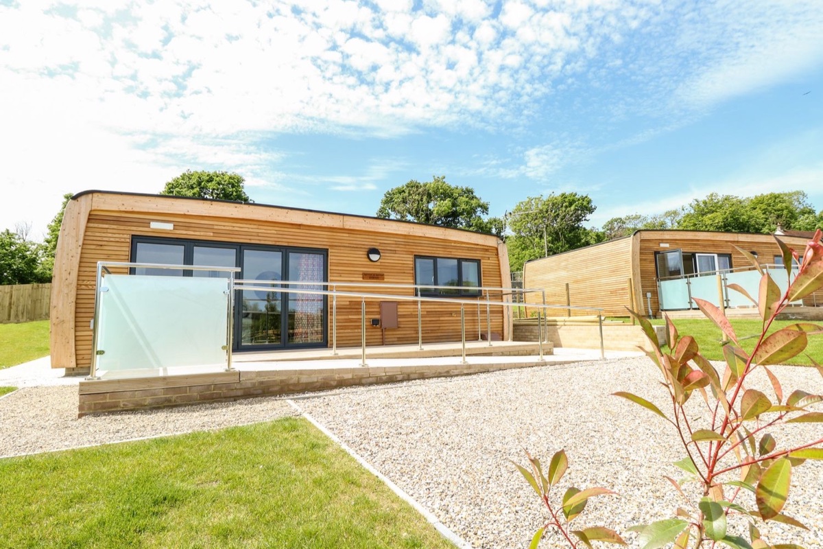 Syrah timber lodge exterior with glass deck rails in Seaview
