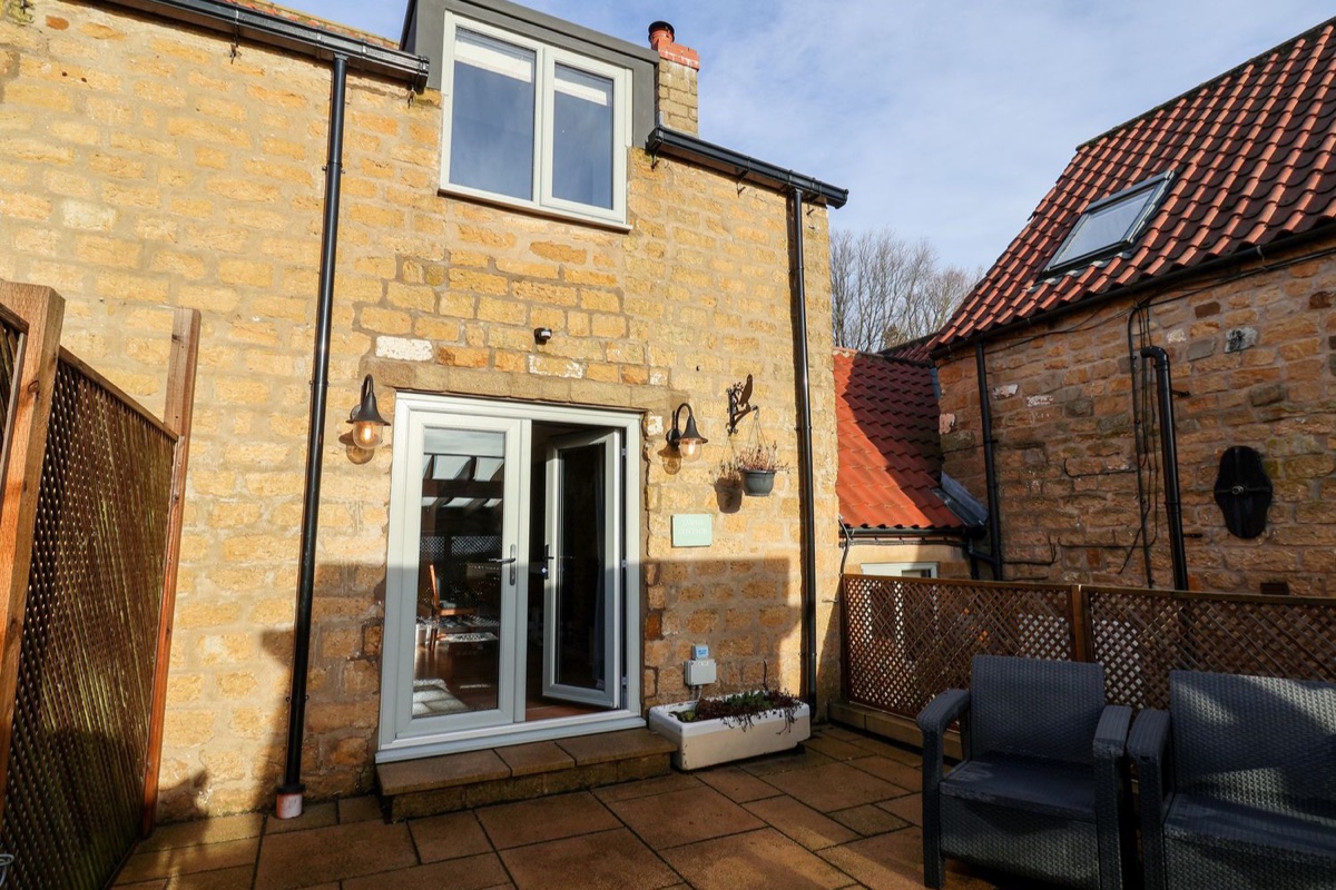 Tawny Cottage stone rear patio with French doors and seating