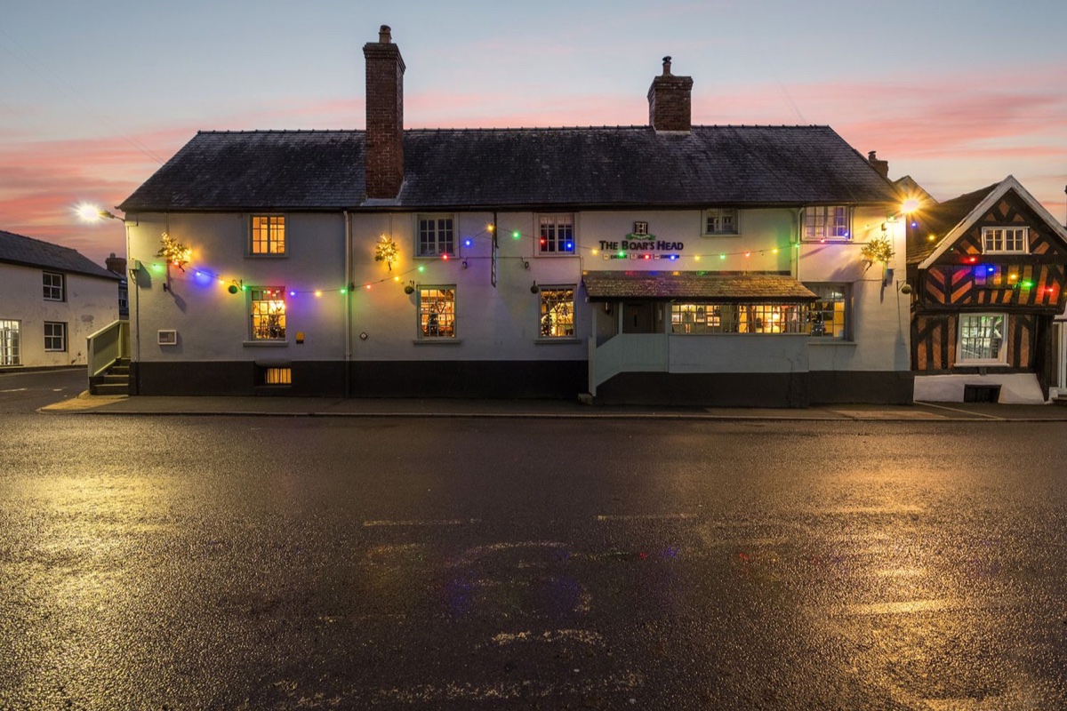 The Boars Head Pub exterior lit at dusk in Bishop's Castle