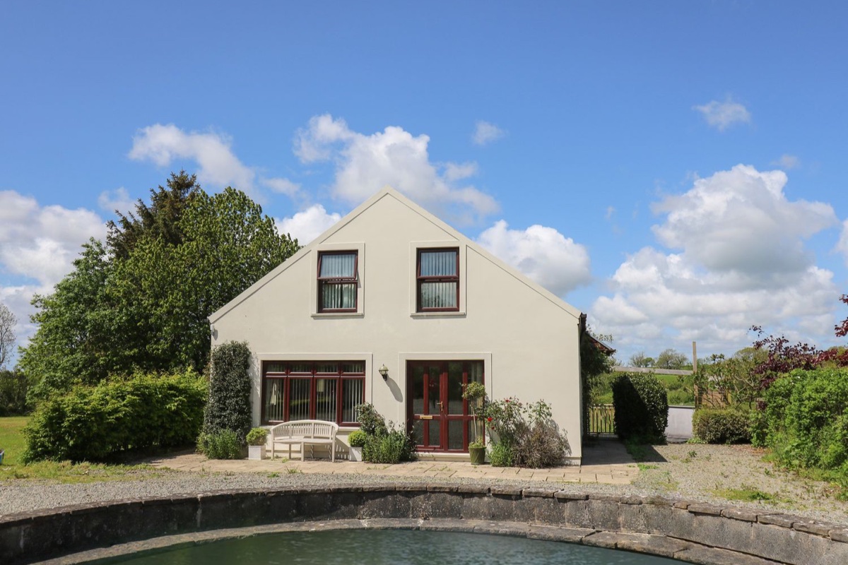 The Clove white house with a wildlife pond and lawns at Poyston Cross