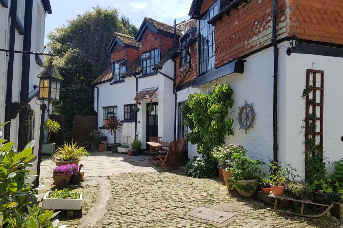 The Coach House cottage exterior and cobbled courtyard in Newport