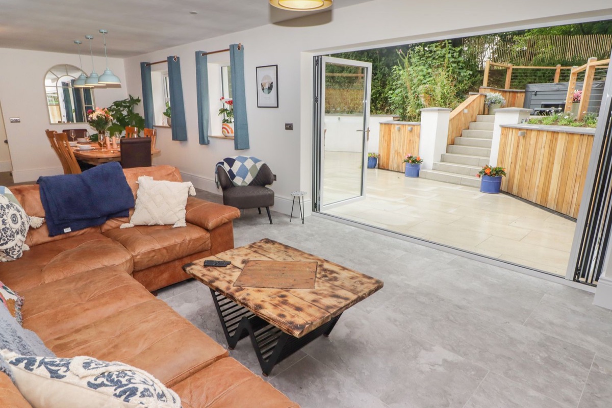 Living room with bifold doors open onto the terrace at The Grove in Wolfsdale