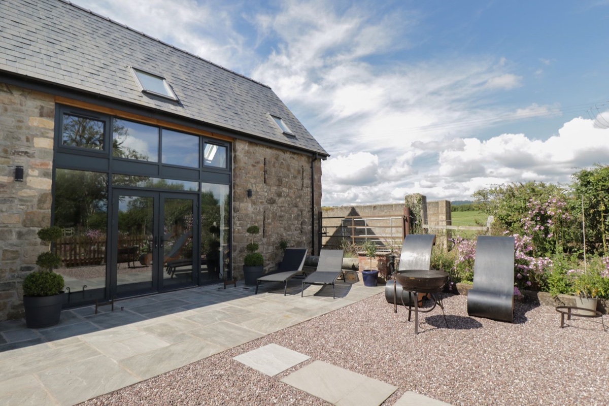 The Hay Barn stone exterior with lawn and outdoor seating