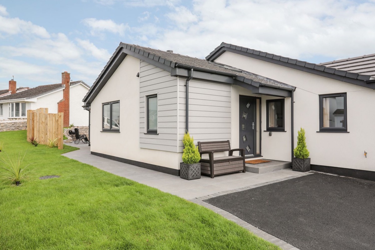 The Herun modern exterior with lawn and bench
