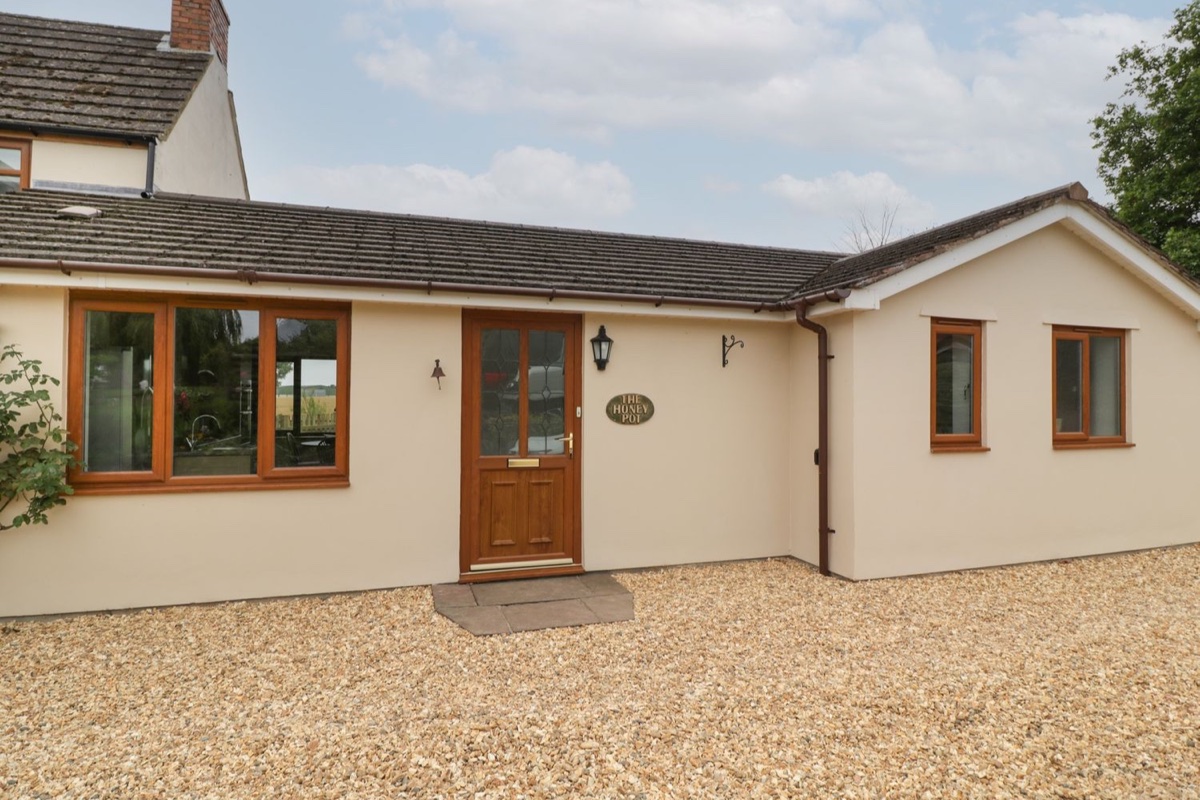 The Honey Pot cottage exterior with stone walls and a garden path