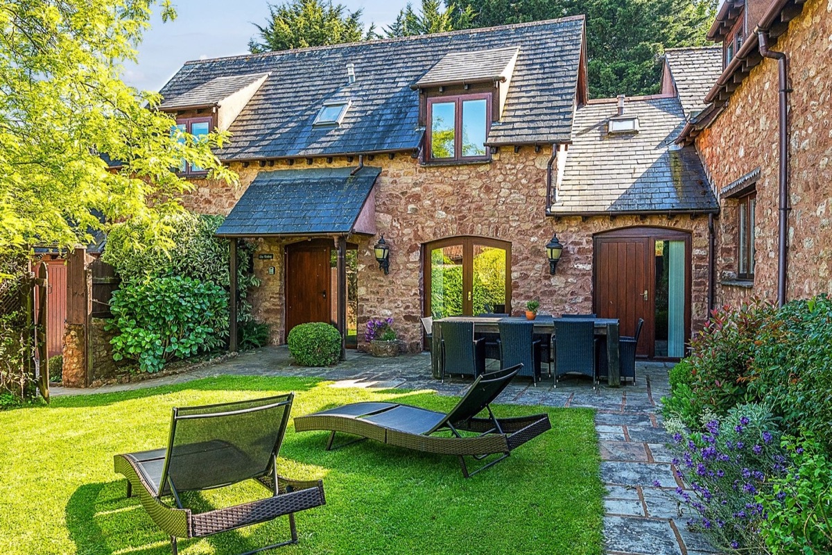 The Linhay garden seating outside a stone house in Washford