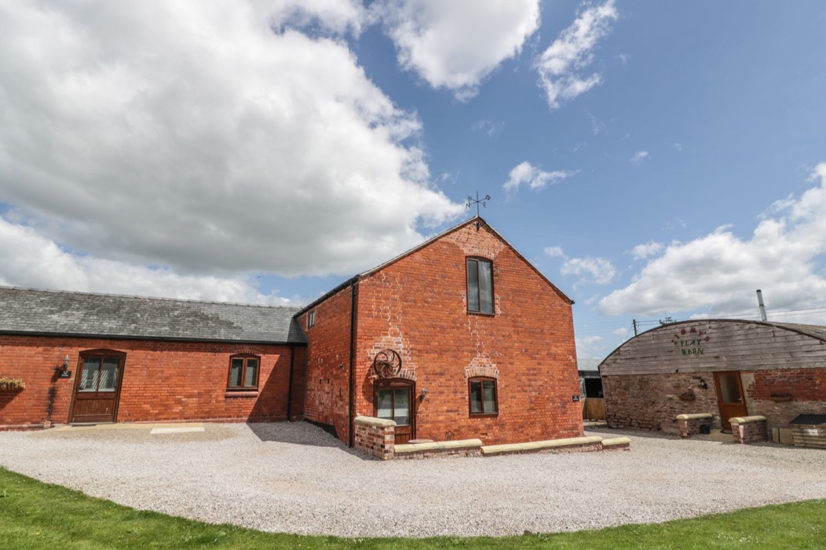 The Mill House red-brick exterior beneath a broad cloudy sky