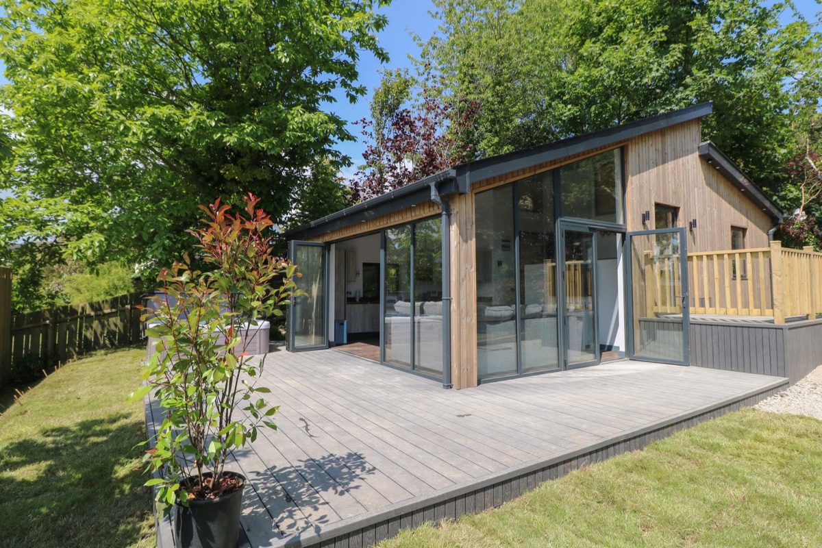 Wooden cabin with glass doors and deck at The Nest Brython
