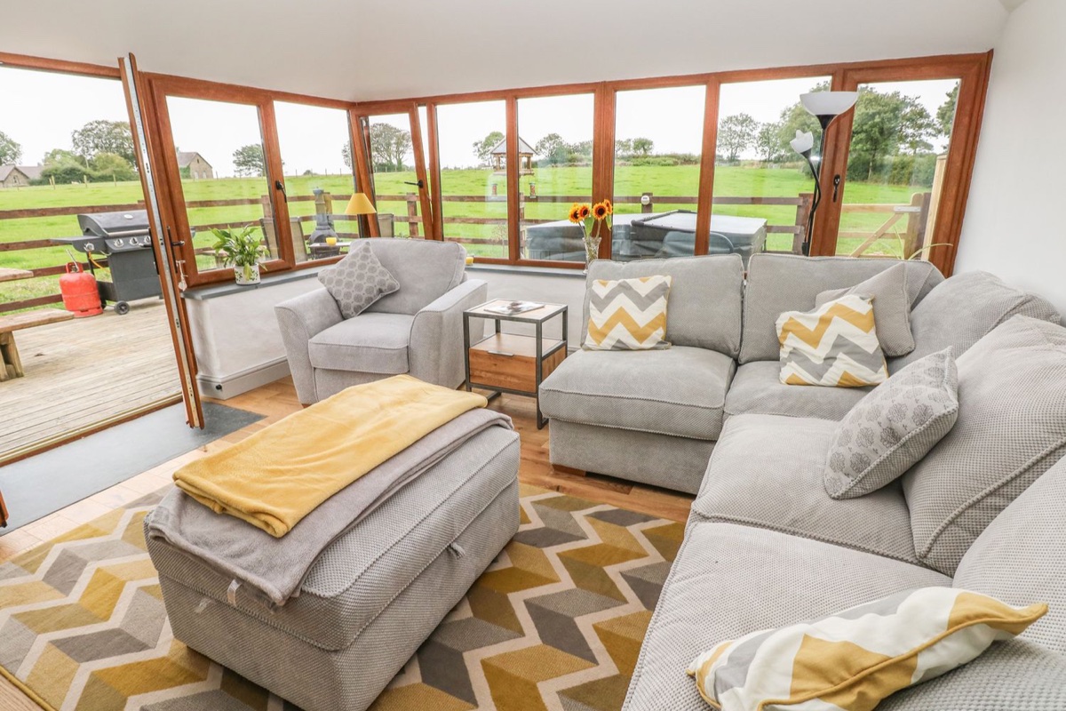 Garden room with wraparound windows over open fields at The Old Farm Shop
