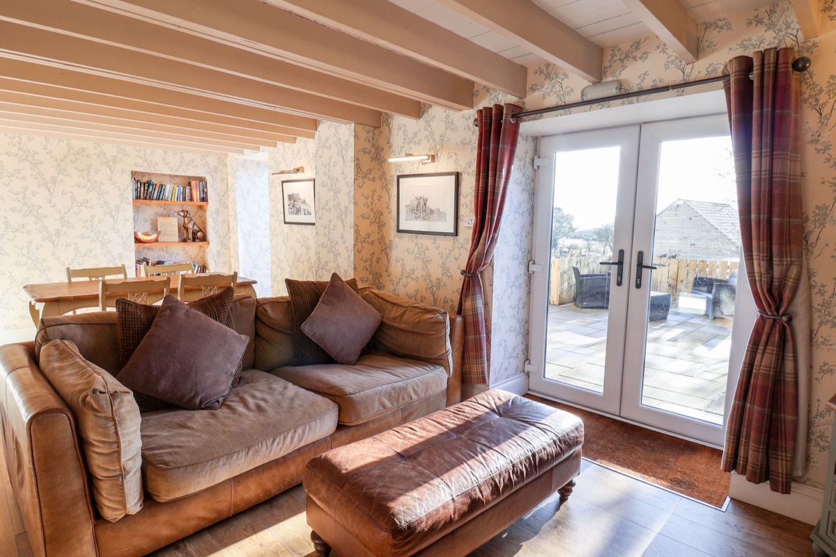 The Pheasantry lounge with leather sofa and French doors to the patio