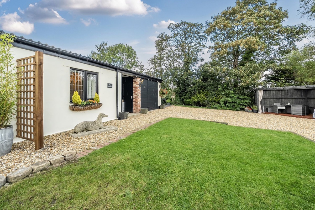 The Stables exterior with lawn and hot tub in the garden