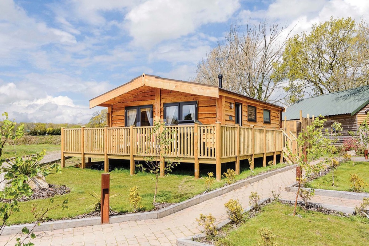 Typhoon Lodge timber cabin with deck in a landscaped garden