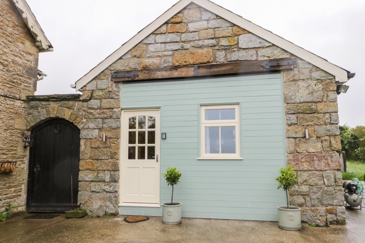 Wagtail Nest stone cottage frontage with pale blue timber door