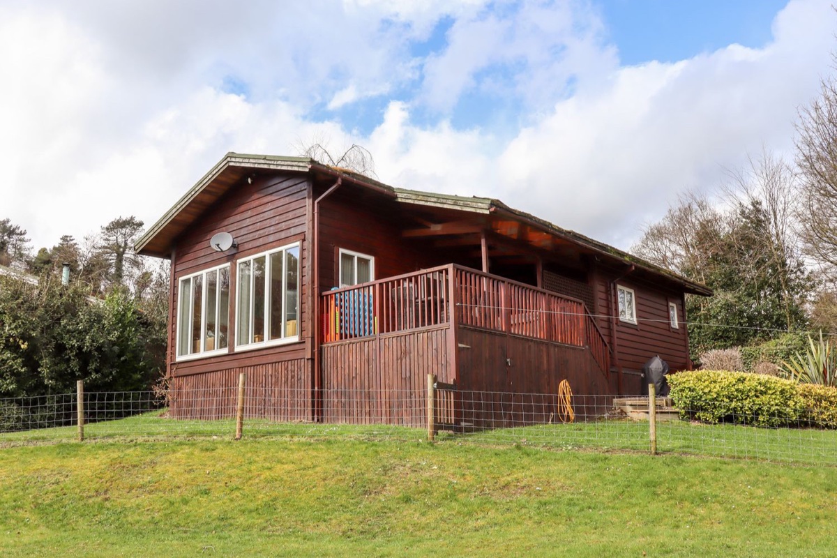 Timber lodge with a veranda on a grassy plot at Watersview Lodge near Rudyard Lake
