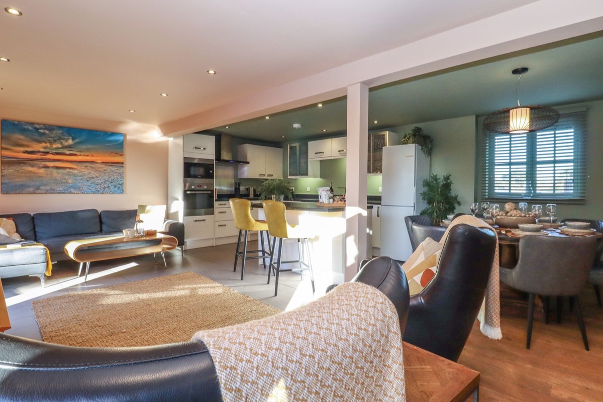 Open-plan living, kitchen and dining area with a wood floor at Willow Cottage near Rye