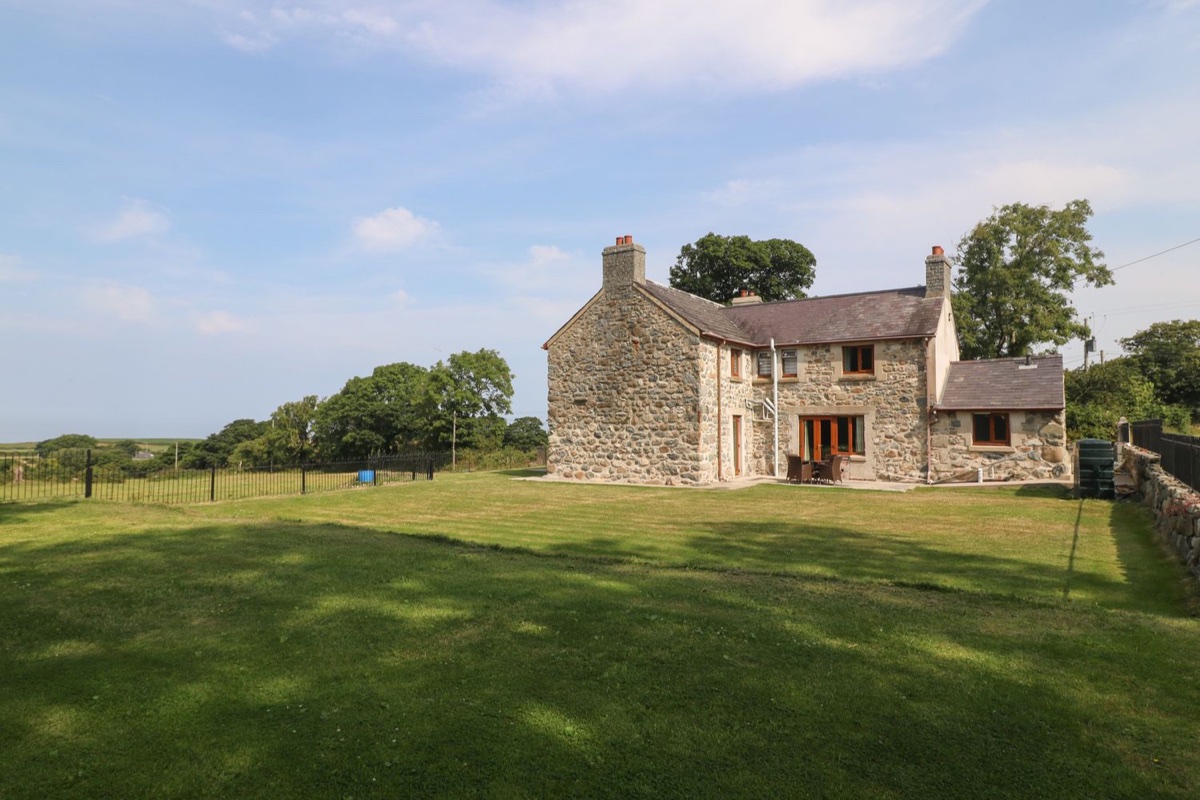 Y Berth Ddu Farmhouse exterior with lawn