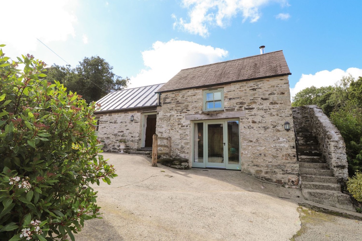 Stone barn frontage of Y Felin at Coed Cadw with two entrances and outdoor steps